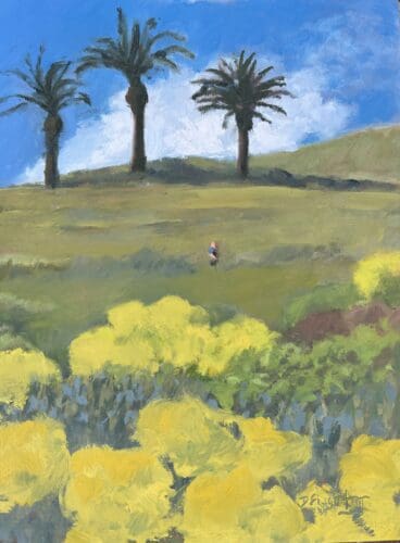 Doug Singletary strolls on a grassy hill with three palm trees in the background and yellow shrubs in the foreground, all under a blue sky with scattered clouds.