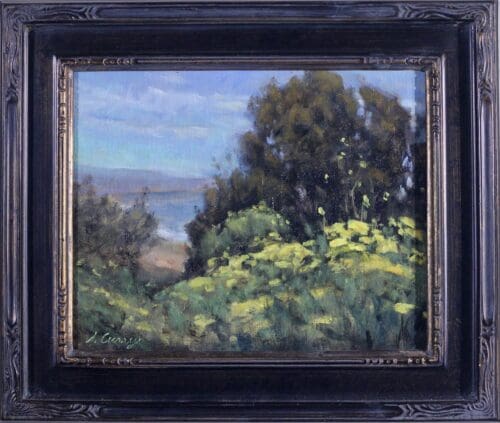 A framed painting depicting a coastal landscape with trees, bushes, and yellow flowers in the foreground. The sky and sea are visible in the background.